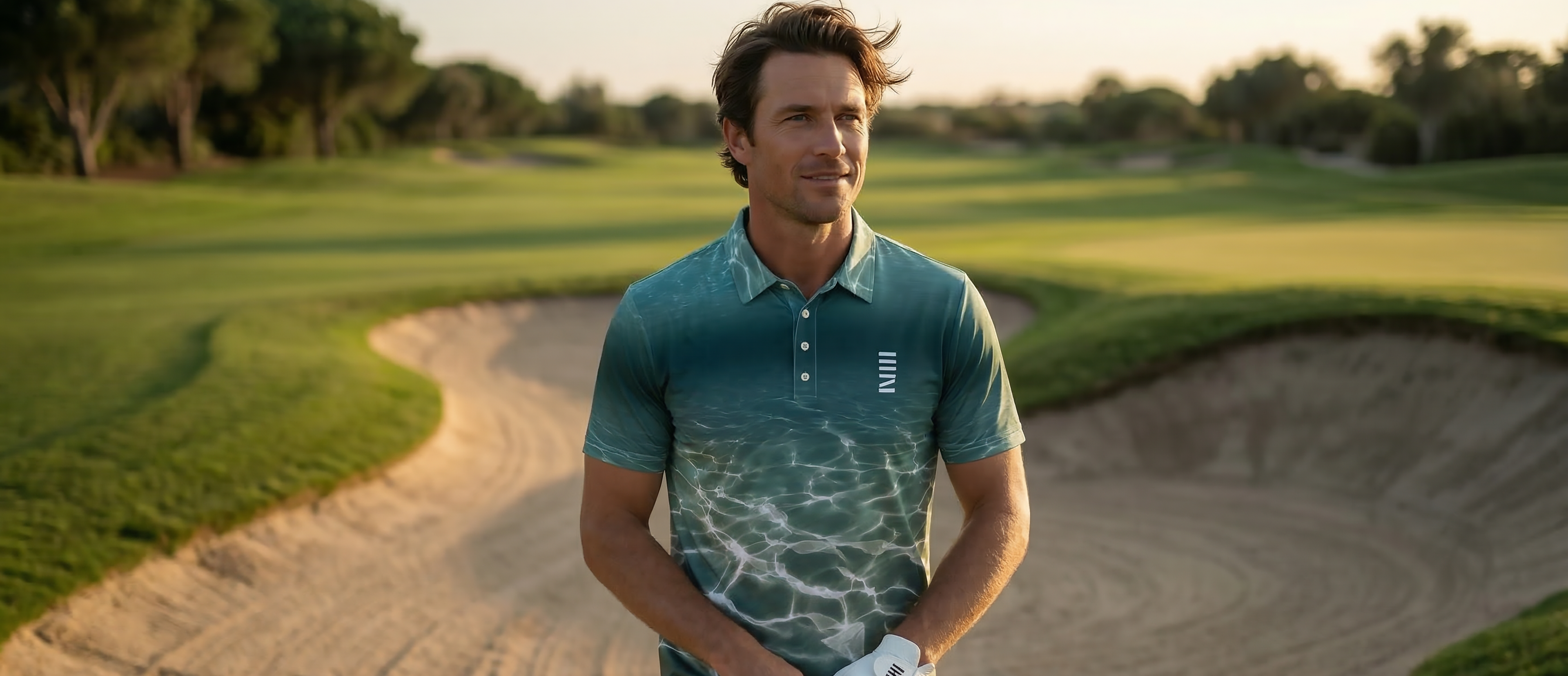 Man holding a golf club on a golf course with sand bunkers and green grass in the background