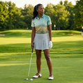 Woman playing golf on a green course with trees in the background