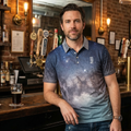 Man standing in a bar wearing a blue polo shirt with a starry pattern.